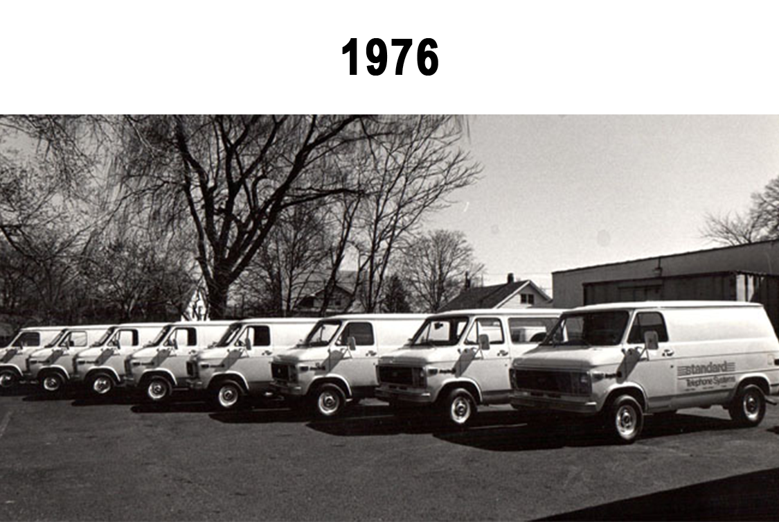 A picture showing vans in line showcasing Standard Telephone Systems established in 1976.