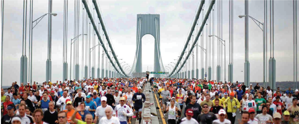 A crowd of people running on a bridge during a marathon race.

