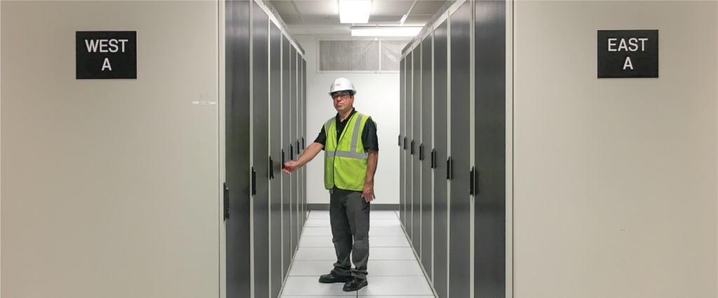 USIS supervisor standing at multinational bank, NJ campus with furnished and installed CAT-6 and Fiber Optic Infrastructure.
