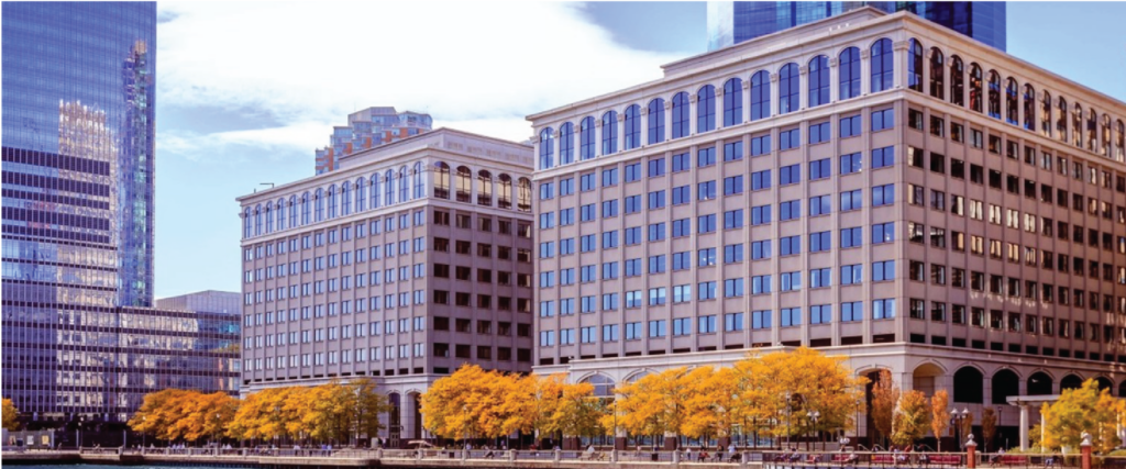 Modern cityscape with office buildings and autumnal trees.

