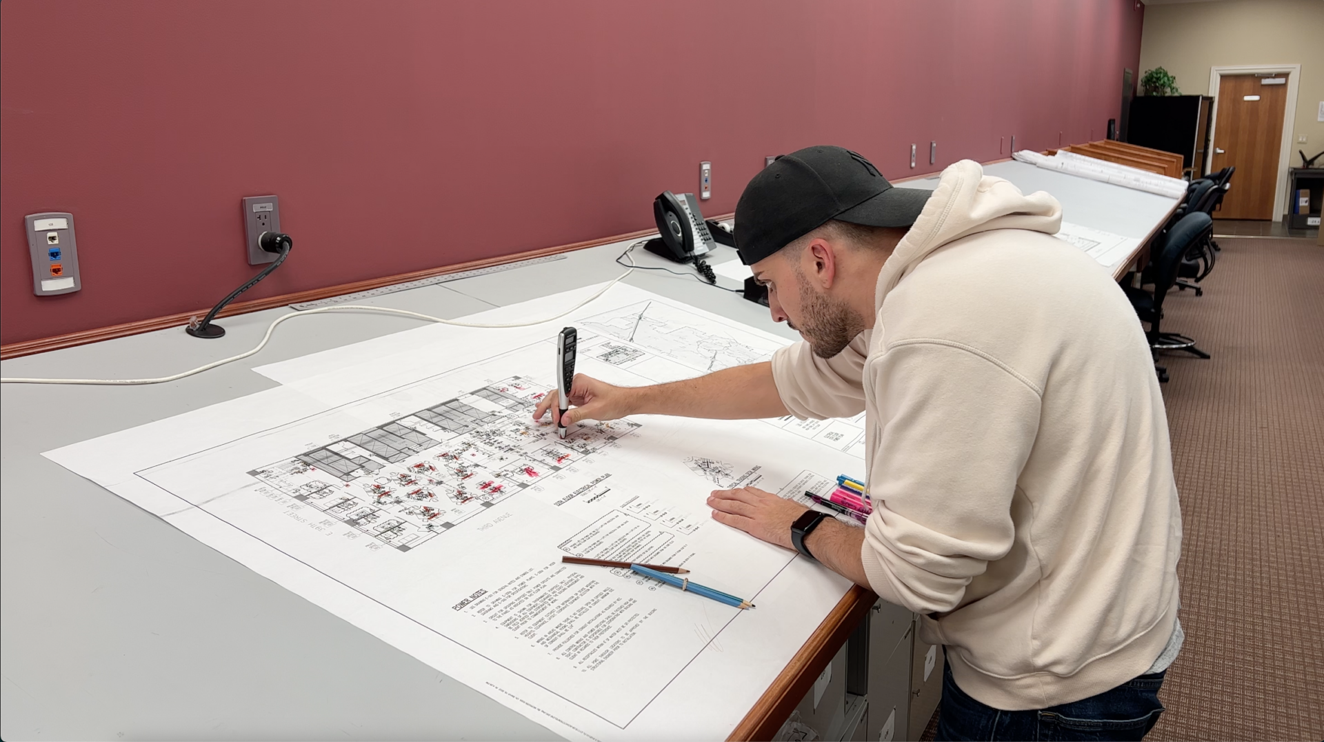 An employee analyzing blueprints working in USIS office. 