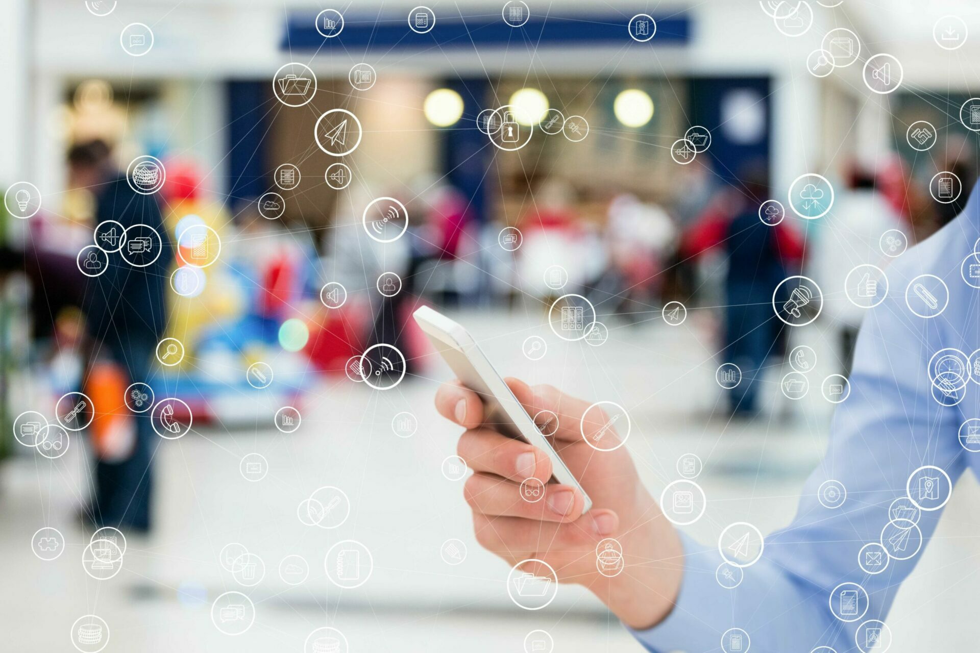 A person holding a phone with dispersed IT and social icons