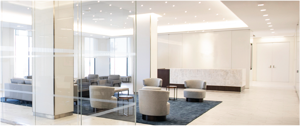 A contemporary office lobby with transparent glass walls and sleek chairs.

